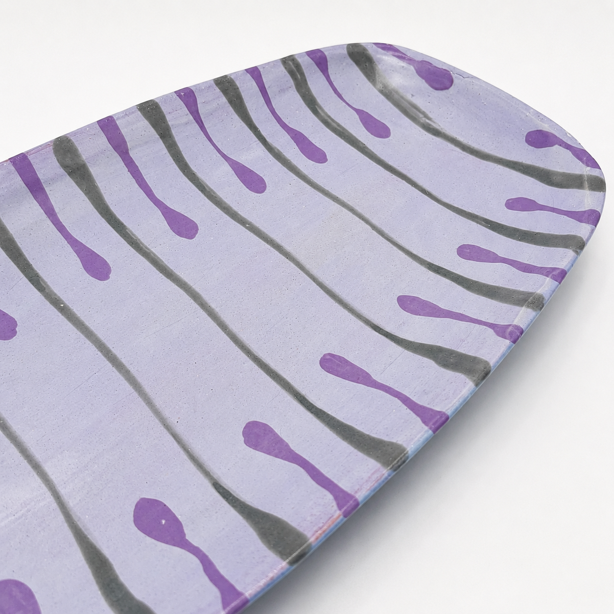 Detail view of Beni oven-safe ceramic serving platter showing purple and gray drip glaze pattern
