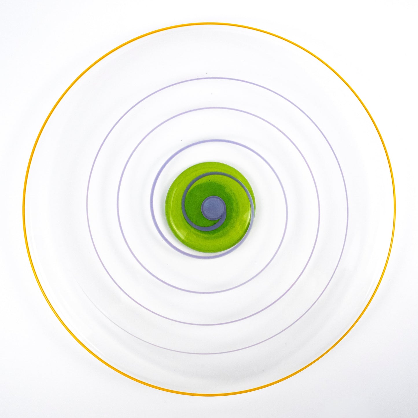 A top-down view of a clear circular plate with concentric rings in yellow, purple, and green, centered on a white background.