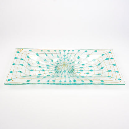 A rectangular clear glass platter with a hand-blown turquoise and gold pattern, photographed on a seamless white background.