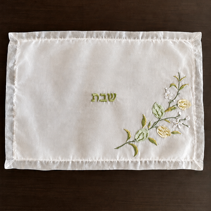 a white organza embroidered challah cover with hand embroidered lemons and limes 