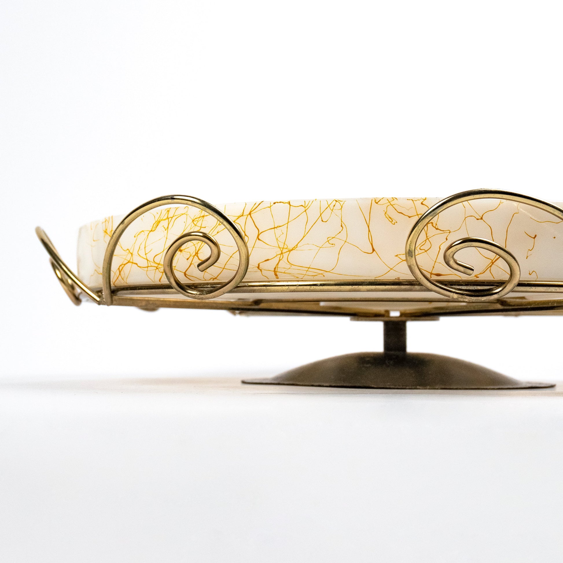 A close-up of a decorative tray with a cream-colored glass surface featuring gold crackle veining, supported by a gold-toned metal wire frame and stand on a white background.