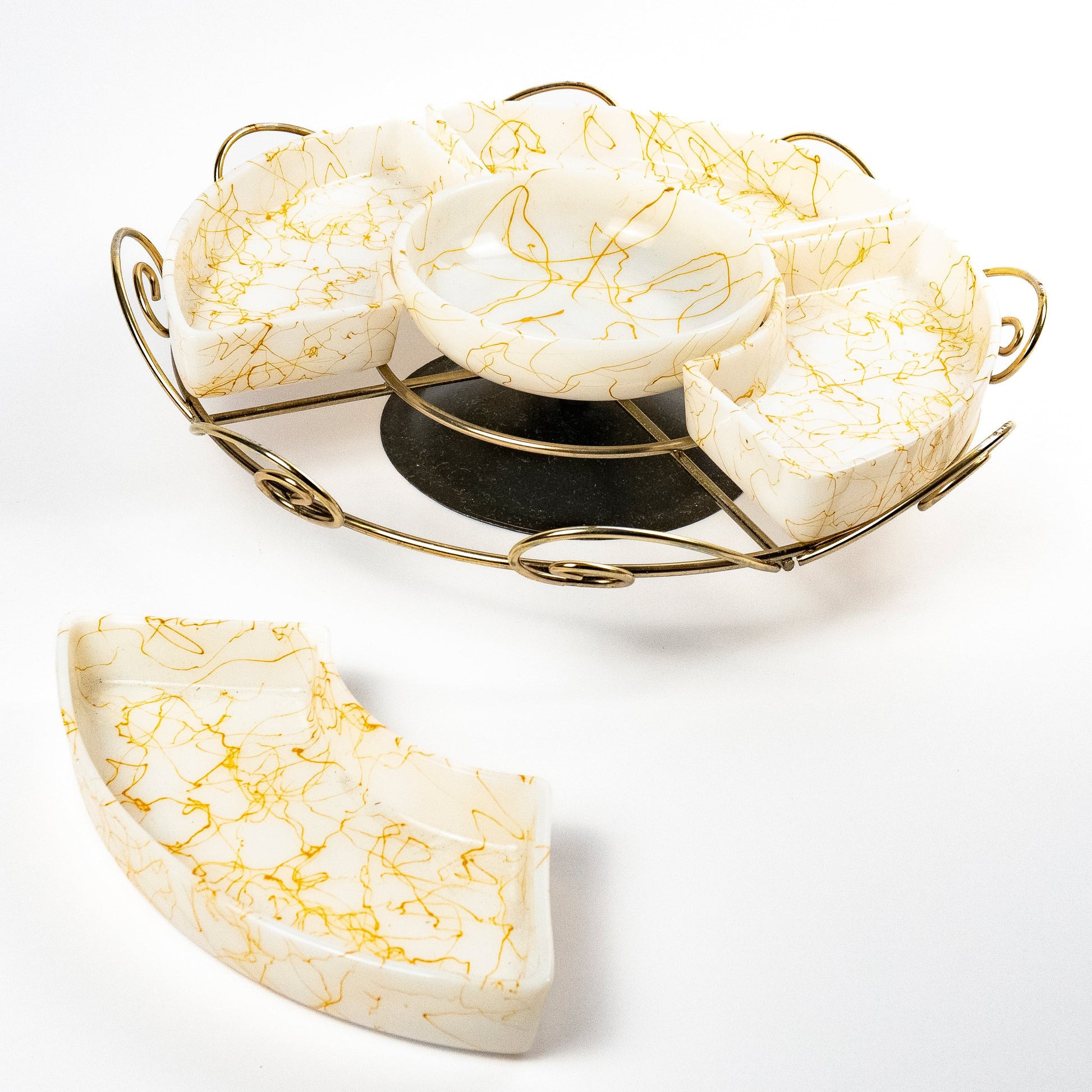 A white glass sectioned serving platter with a gold brass swivel base