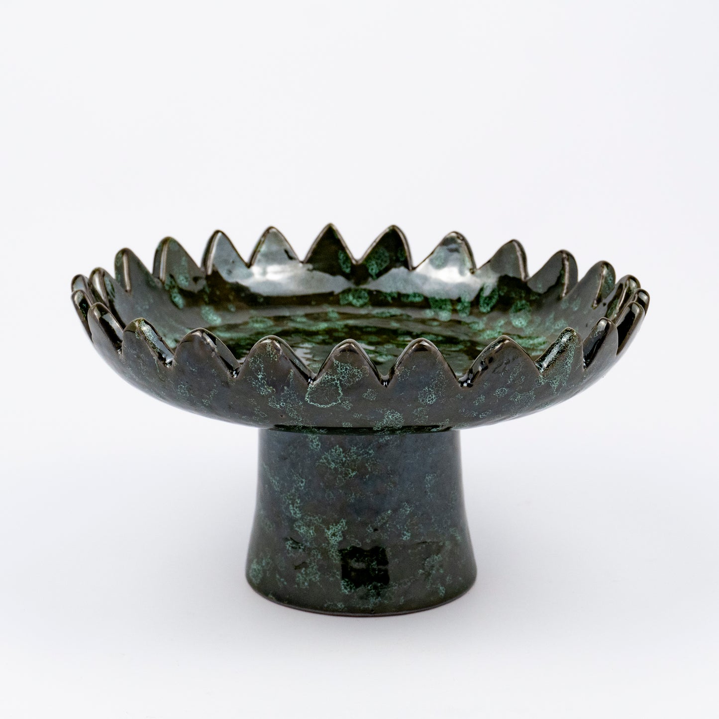 Floree ceramic pedestal bowl, deep green with black speckle glaze, sawtooth zigzag rim, footed base