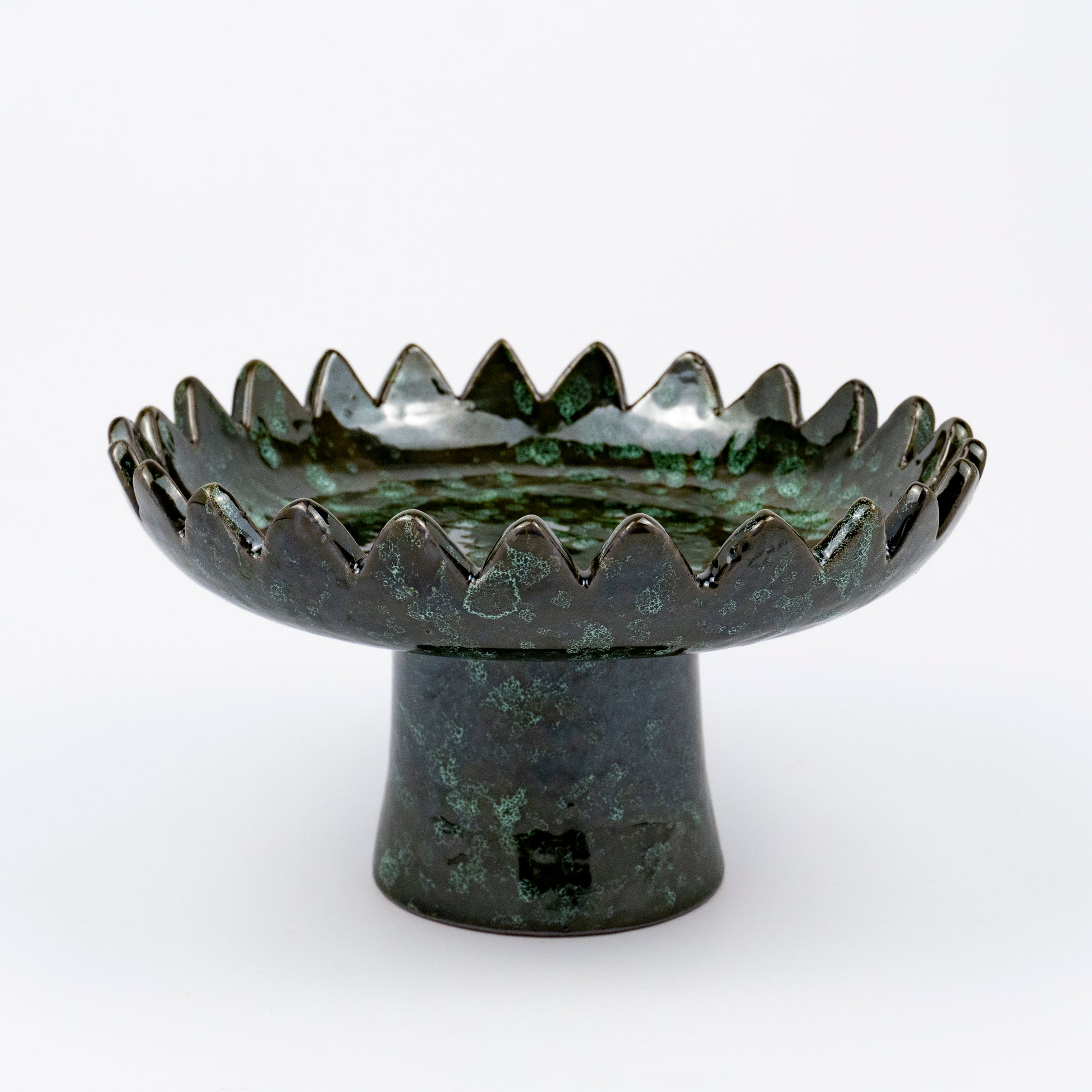 Floree ceramic pedestal bowl, deep green with black speckle glaze, sawtooth zigzag rim, footed base