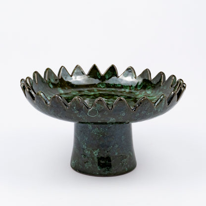 Floree ceramic pedestal bowl, deep green with black speckle glaze, sawtooth zigzag rim, footed base