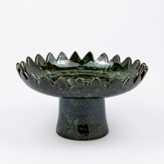 Floree ceramic pedestal bowl, deep green with black speckle glaze, sawtooth zigzag rim, footed base