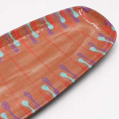 Detail view of Lonza oven-safe ceramic serving platter showing coral, purple, and turquoise drip glaze pattern
