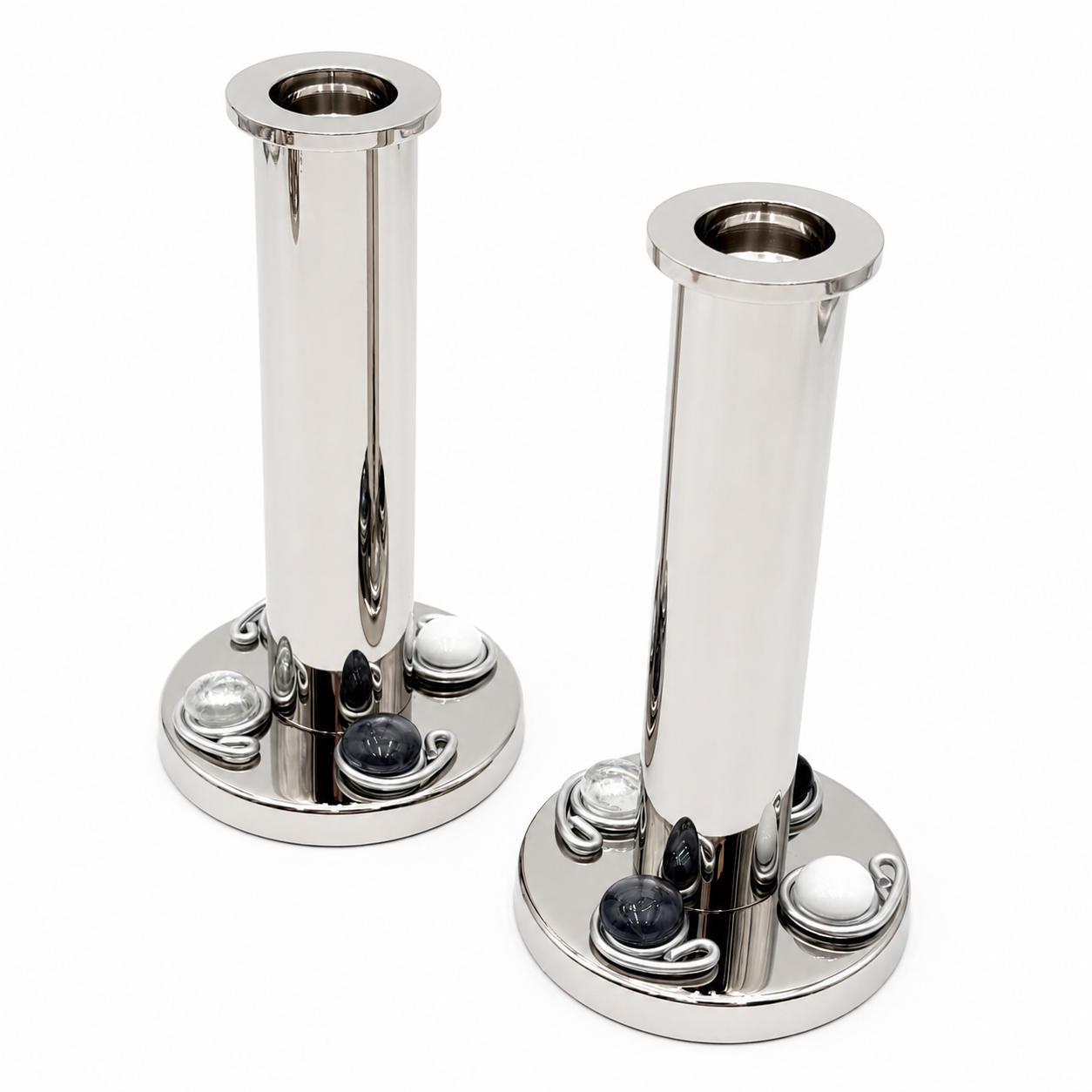 Two polished silver candlestick holders with black and white gemstones 