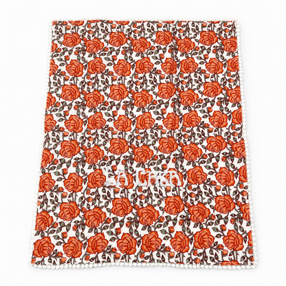 Close up of Orly La Casa coral rose floral guest towels, white LA CASA embroidery, pom-pom trim, set of two