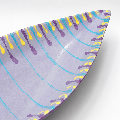Detail view of Santino oven-safe ceramic serving bowl showing colorful drip glaze pattern and pointed edge