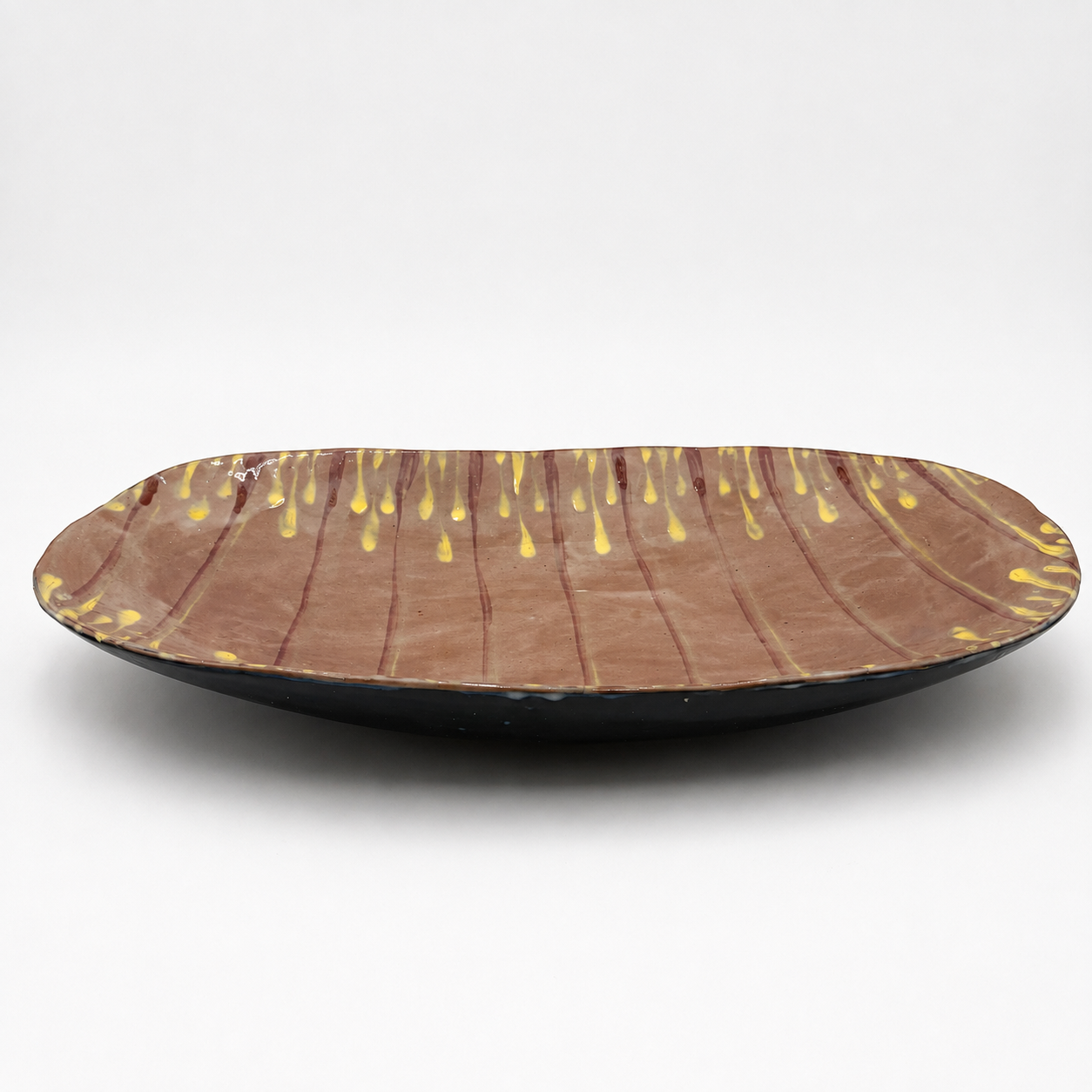 Side view of Taro oven-safe ceramic serving bowl showing dark exterior glaze and shallow oval profile