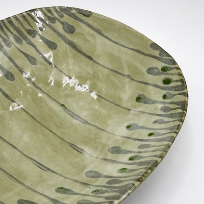 Detail view of Varde oven-safe ceramic serving bowl showing gray drip glaze lines and green accent dots