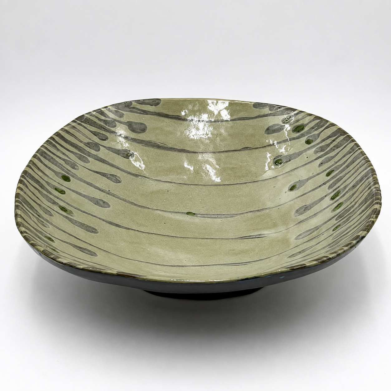 Side view of Varde oven-safe ceramic serving bowl showing dark exterior glaze and organic drip pattern interior