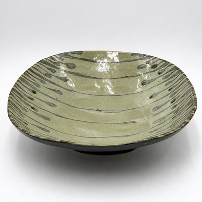 Side view of Varde oven-safe ceramic serving bowl showing dark exterior glaze and organic drip pattern interior