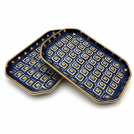 Two Violetta Maiolica ceramic serving dishes shown together, navy blue geometric pattern and gold rim